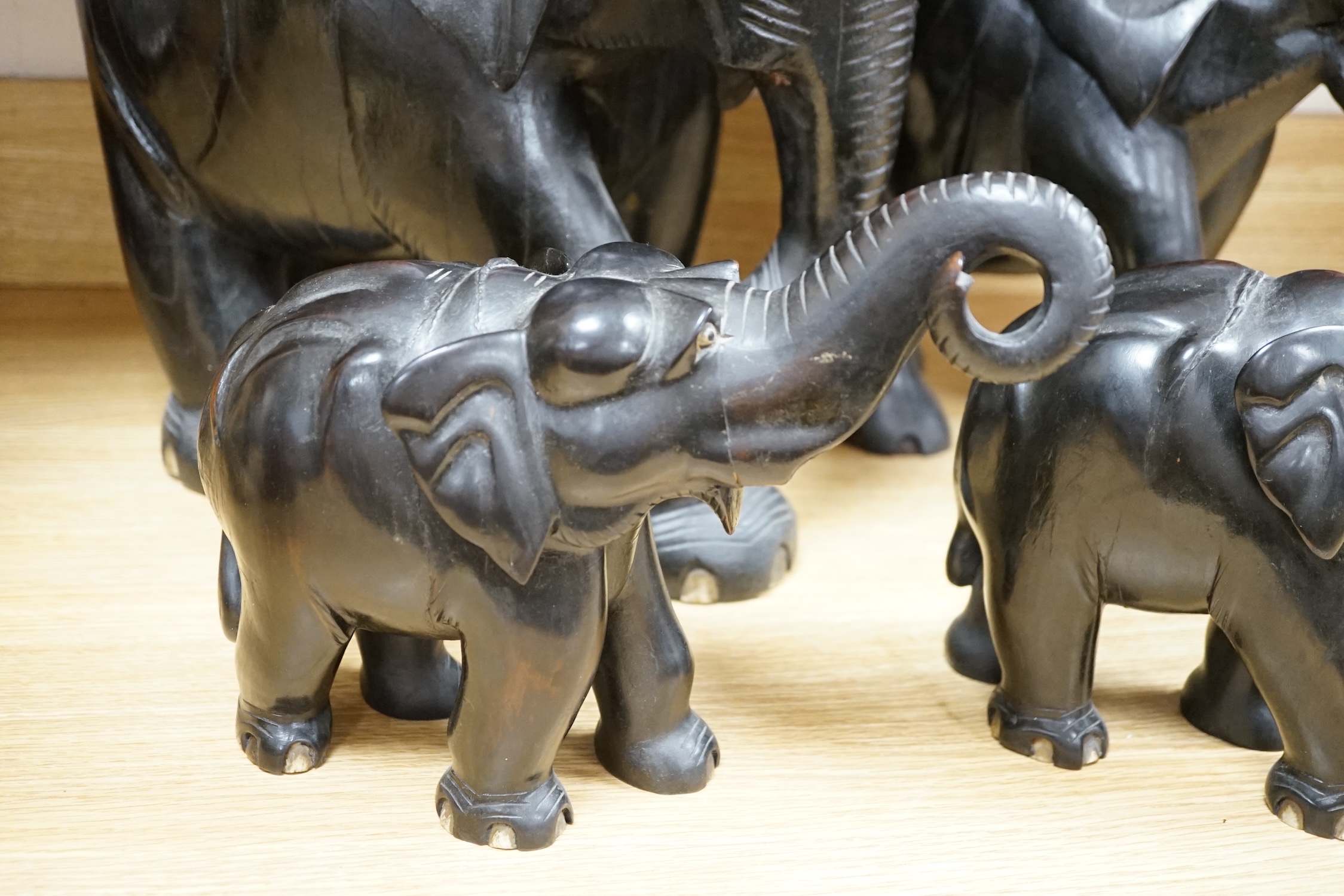 Two large carved ebony elephants and two smaller similar elephants